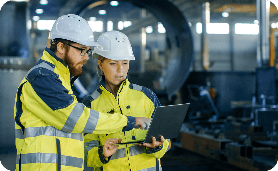 Two engineers reviewing workforce data on a laptop